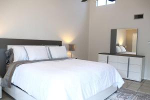 a bedroom with a large white bed and a mirror at 2 BDR with Workspace & Patio in Montrose in Houston
