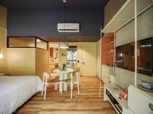a bedroom with a bed and a table and chairs at The Somos Flats Provenza in Medellín