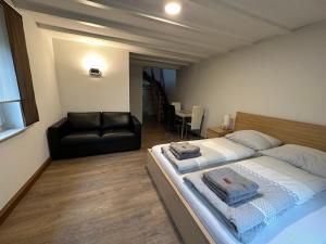 a bedroom with a bed and a black couch at Ferienwohnung zum Winterberg in Elsterwerda