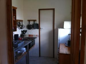 a kitchen with a white door and a refrigerator at Guinea Fowl Loft in Knysna