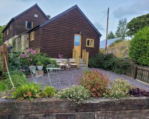 a small wooden house with a garden in front of it at Kettle Tree Cabin in Welshpool