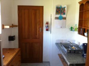 a kitchen with a white refrigerator and a sink at Guinea Fowl Loft in Knysna