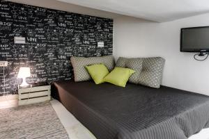 ナポリにあるSanta Lucia Homeの黒い壁のベッドルーム(ベッド1台、テレビ付)