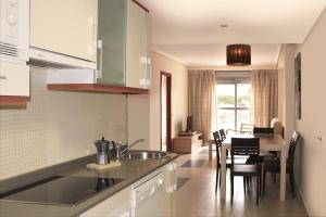 a kitchen with a sink and a table with chairs at Complejo Turístico Marina Rey in Vera