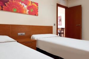 1 dormitorio con 2 camas y un cuadro en la pared en Complejo Turístico Marina Rey, en Vera