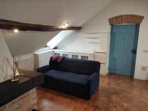 a living room with a blue couch and a blue door at La Mansarda di Vico Mandorla in Savona