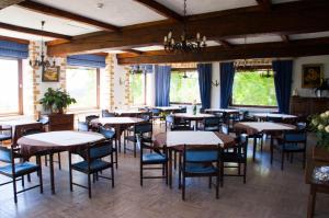 - une salle à manger avec des tables, des chaises et des fenêtres dans l'établissement Hôtel Grand-Champ, à Malmedy