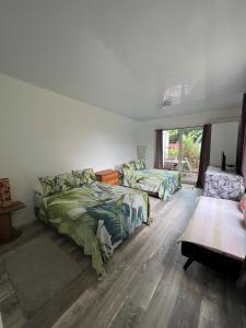 a bedroom with two beds and a table at TEA TAHITI Holidays in Papeete