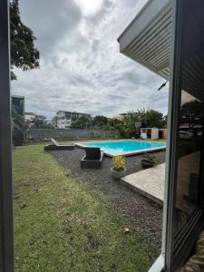 a backyard with a swimming pool and a house at TEA TAHITI Holidays in Papeete