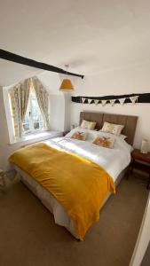 a bedroom with a large bed with a yellow blanket at Cosy Nook in North Molton