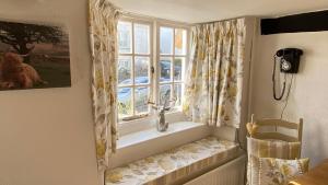 a window seat in a dining room with a window at Cosy Nook in North Molton
