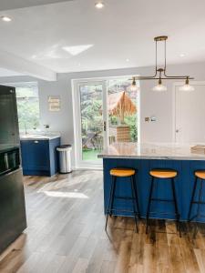 a kitchen with a blue island with bar stools at Dawns House Cromford The Peaks in Cromford
