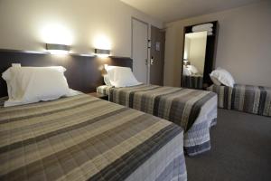 Postel nebo postele na pokoji v ubytování Hôtel Au Petit Caporal