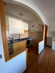a kitchen with white cabinets and an archway at Casa di Lea in Bibbiena