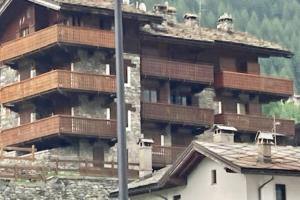 a large building with wooden balconies on a mountain at appartamento valtournenche il nido in Valtournenche
