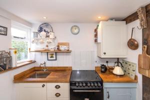 a kitchen with a sink and a stove at 2 Fox Cottages in Darsham