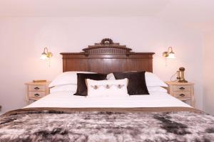 a bedroom with a large bed with a wooden headboard at 2 Fox Cottages in Darsham