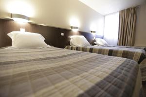 Postel nebo postele na pokoji v ubytování Hôtel Au Petit Caporal