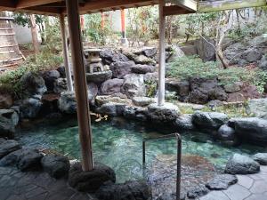 a pool of water in a garden with rocks at Kasuga Hotel in Nara