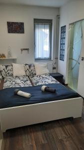 カポシュヴァールにあるPete Lajos Design Apartmanのベッドルームにミット2つ付きの大型ベッド1台が備わります。