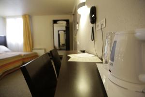 Postel nebo postele na pokoji v ubytování Hôtel Au Petit Caporal