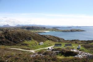 une maison sur une colline à côté d'une masse d'eau dans l'établissement Fern Cottage, à Lairg 21 autres photos