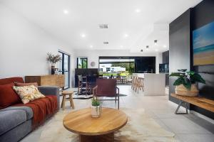 a living room with a couch and a table at Executive, modern waterfront house in Maroochydore