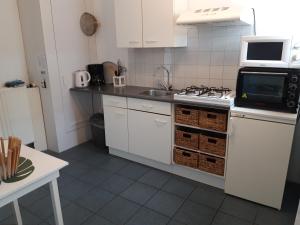 een keuken met een fornuis en een magnetron bij Vakantiewoning 100m van het strand met 1 Slaapkamer in Westkapelle