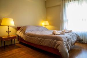 1 dormitorio con 1 cama con 2 almohadas y ventana en Departamento con bella vista a la montaña y ciudad en Mendoza