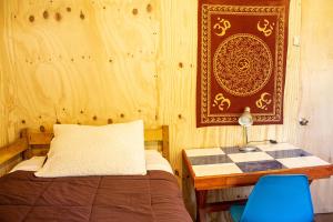 a bedroom with a bed and a table with a lamp at Azurita in Futaleufú