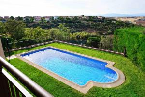 einen Pool auf einem üppigen grünen Hof in der Unterkunft La Encina, casa tranquila con excelentes vistas in Mesones