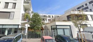 a parking lot with cars parked in front of a building at Paris La-Defense - U Arena - 2 Bedrooms - Parking, Terrace & Wifi in Nanterre