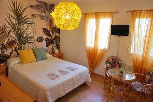 a bedroom with a bed and a table and a chandelier at La Encina, casa tranquila con excelentes vistas in Mesones +38 photos