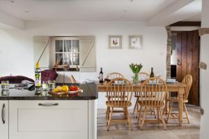 a kitchen and dining room with a table and chairs at Hope Cottage in Quenington