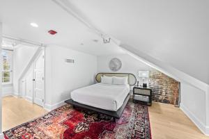 a white bedroom with a bed and a rug at The Graham Georgetown in Washington, D.C.