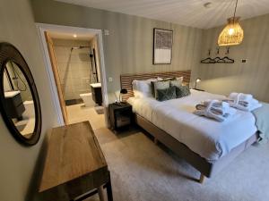 a bedroom with a large bed and a mirror at Walnut House, Ashlin Farm Barns in Lincoln
