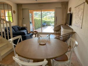 een woonkamer met een houten tafel en stoelen bij Villa "Les Greens" - Ste Maxime - 6 pers - Wifi - Proche Plages et Centre-Ville in Sainte-Maxime