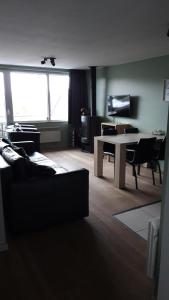 a living room with a couch and a table with a desk at Terrasses de Malmedy - Duplex 455 in Malmedy