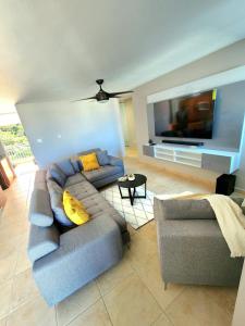 a living room with a couch and a flat screen tv at Hillside Village Retreat in Rio Grande