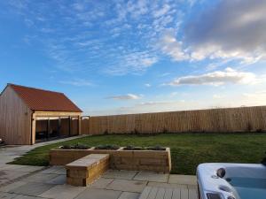 a backyard with a garden with a wooden fence at Rowan House, Ashlin Farm Barns in Lincoln