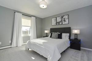 Un dormitorio con una gran cama blanca y una ventana. en *NEW* Beautiful 3 floor Townhome with Sauna, en Manchester