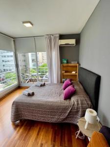 a bedroom with a large bed with purple pillows at Palermo Tessa I Appartment in Buenos Aires