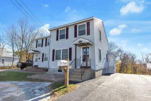 Una casa blanca con un cartel delante en *NEW* Beautiful 3 floor Townhome with Sauna, en Manchester