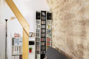 Una sala de estar con una estantería llena de libros. en La Casina Apartment, en Alghero