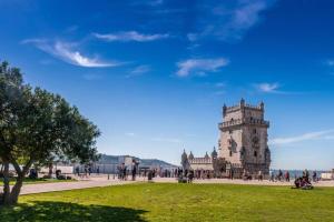 a building with a tower in a field of grass at Jerónimos Apartments best place in Lisbon - 1º D in Lisbon
