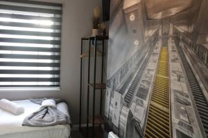 a bedroom with a wall with a poster of a train at Quaint Studio Flat in the Heart of London in London