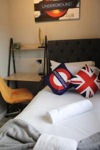 a bedroom with a bed with pillows and a chair at Quaint Studio Flat in the Heart of London in London