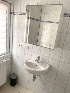 a white bathroom with a sink and a mirror at Apartment Sonnenschein in Allersberg +19 photos