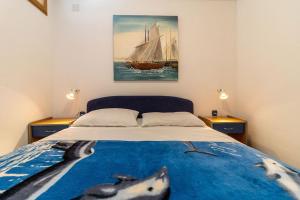 a bedroom with a bed with a painting on the wall at Villa Tiha luka in Neum