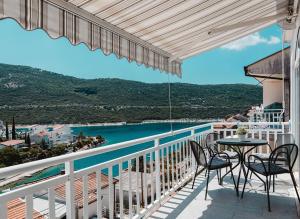 a balcony with a table and chairs and the ocean at Villa Tiha luka in Neum